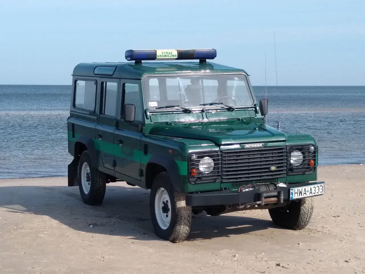 Zielony Land Rover Defender z napisem