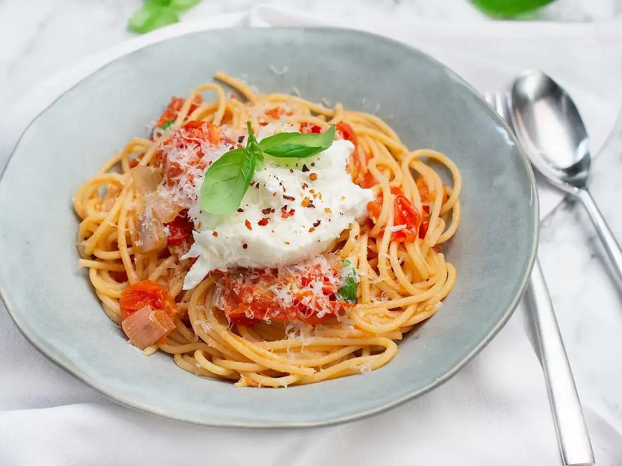 Spaghetti med tomats&aring;s, toppad med kr&auml;mig burrata och f&auml;rsk basilika. Enkel och uts&ouml;kt pasta burrata.