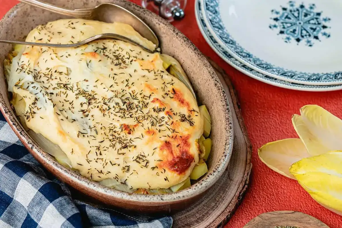 Un gratin de chicons, un plat végétarien réconfortant, recouvert d'une béchamel dorée et d'herbes.