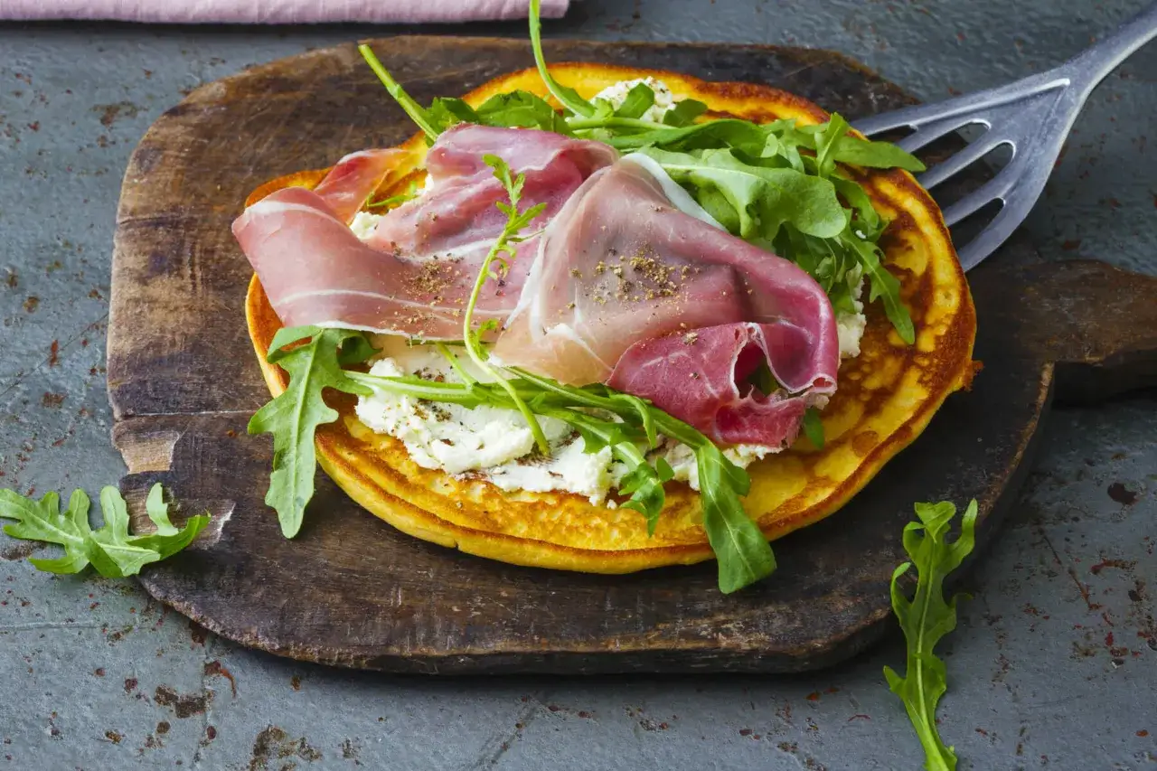 Herzhafte Pfannkuchen mit Frischk&auml;se, Rucola und luftgetrocknetem Schinken, garniert mit Pfeffer. Ein Genuss f&uuml;r jeden Gaumen!