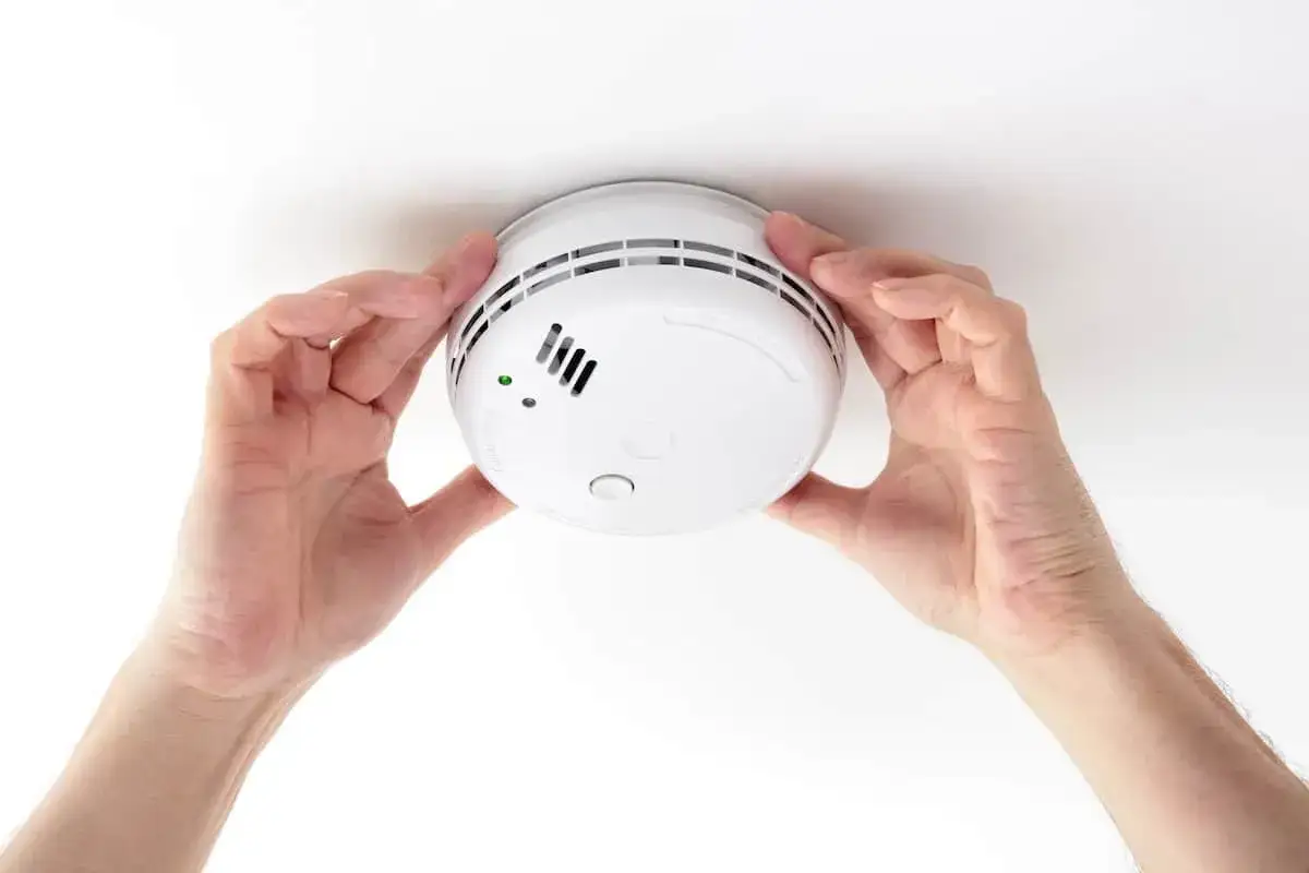 Mains mains installent un détecteur de fumée, garantissant la sécurité de votre foyer. Une attestation détecteur de fumée est essentielle.