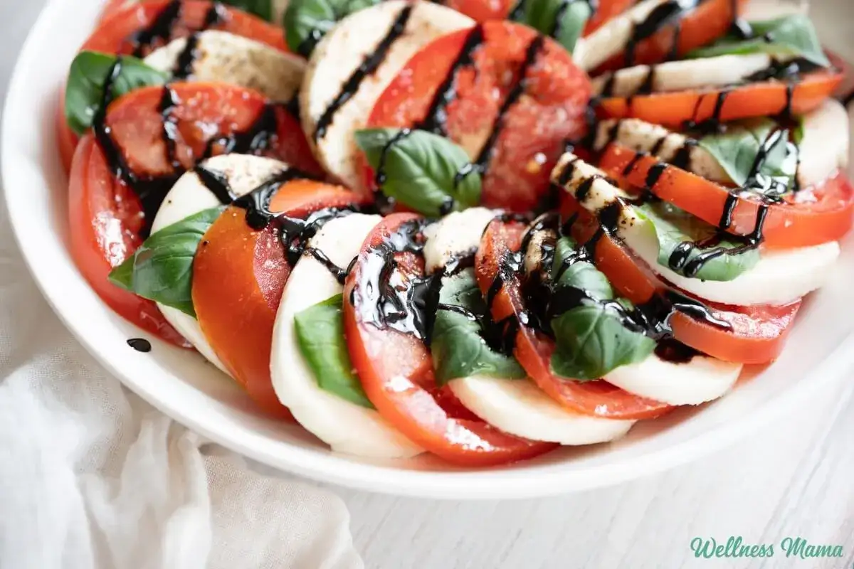 Caprese-Salat mit Tomaten, Mozzarella und Basilikum, betr&auml;ufelt mit Balsamico-Creme.