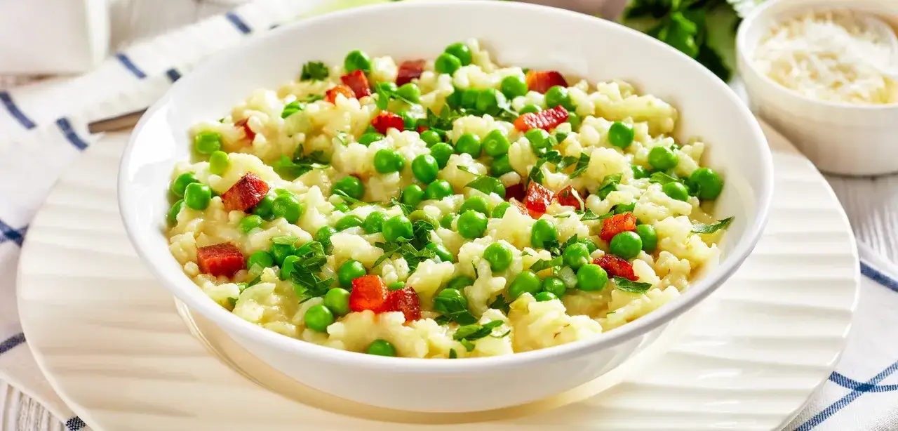Ein cremiges Risi Bisi Rezept original, mit Erbsen und Speckwürfeln, garniert mit Petersilie.