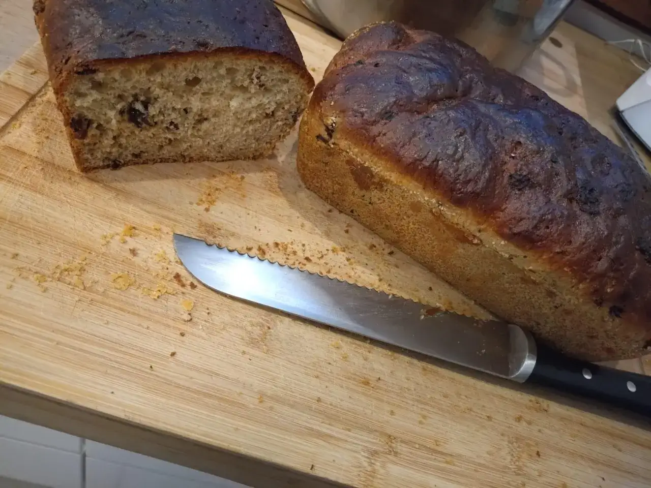 Dwa bochenki chleba na desce, jeden przekrojony. Czy pies może jeść chleb? Nóż czeka na kromkę.