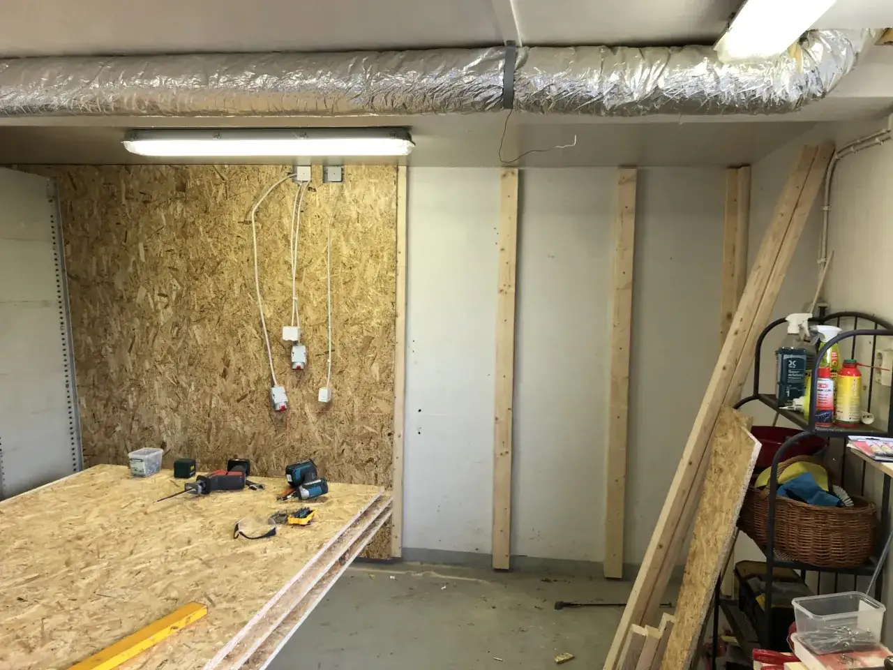 H&auml;r ligger skivor av OSB redo att m&aring;la. Verktyg och byggmaterial finns p&aring; plats f&ouml;r projektet.