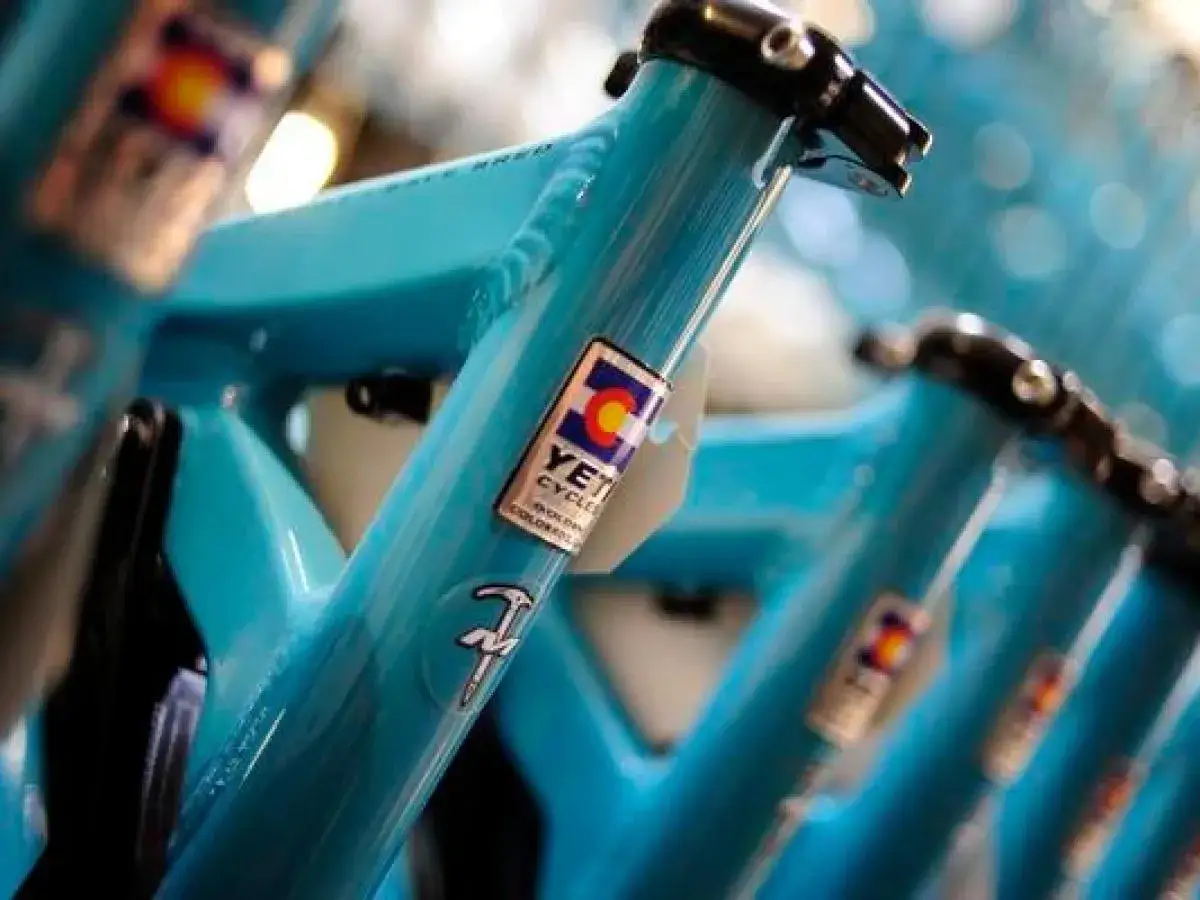 Close-up of turquoise Yeti Cycles frames, showing the Colorado flag logo, hinting where Yeti is made.