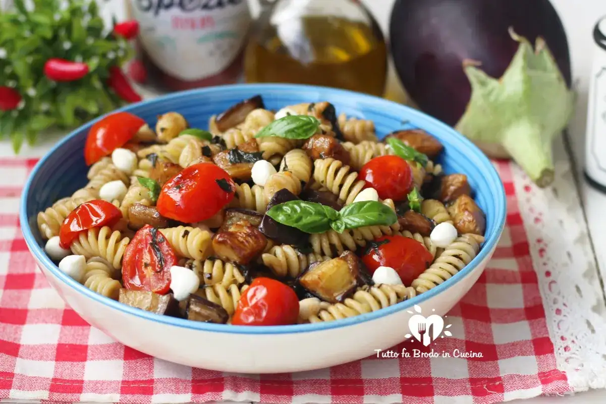 Pasta fredda con melanzane, pomodorini e mozzarelline, un piatto estivo colorato e gustoso.