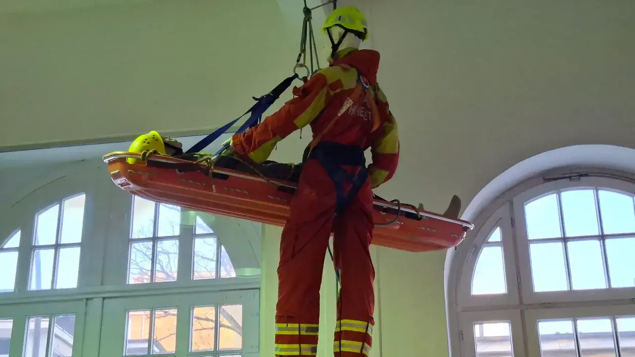 Übung für die fiz Feuerwehr: Eine Übungspuppe wird in einer Schleifkorbtrage von der Decke gehoben.