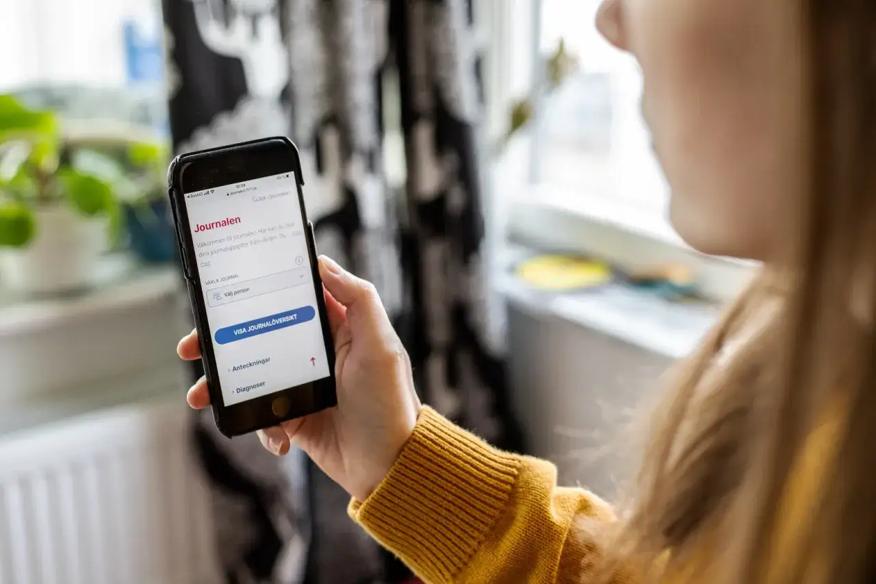 En person kollar sin mobilapp f&ouml;r att se vilka vaccin har jag. Appen visar 