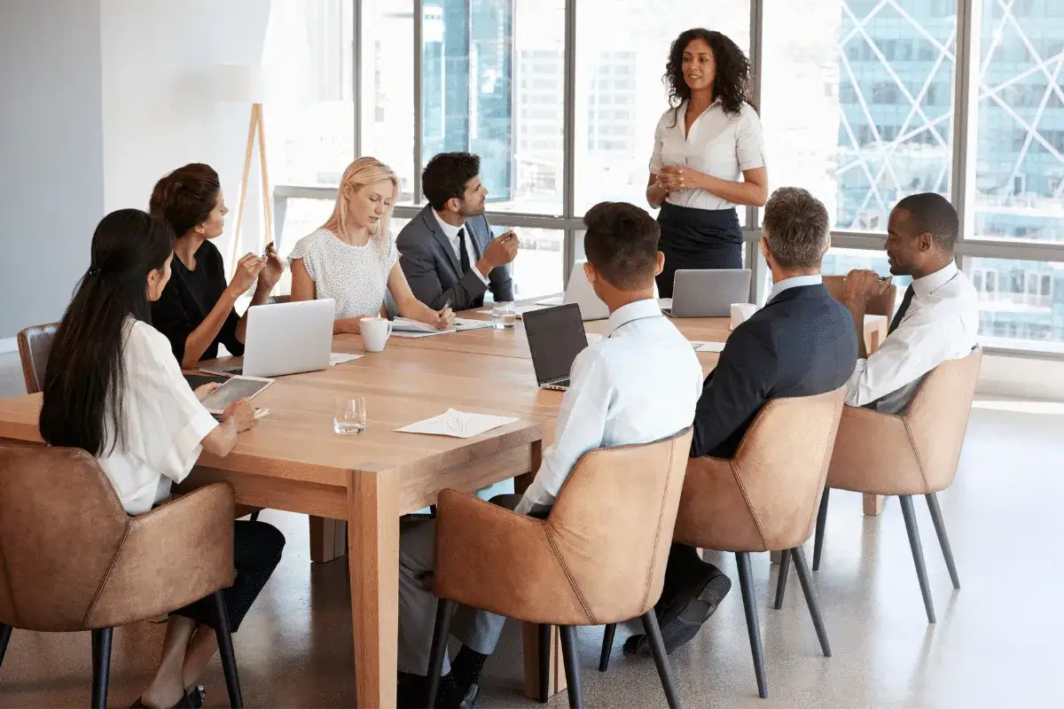 A diverse team collaborates on nonprofit management strategies in a modern boardroom, discussing plans and ideas.