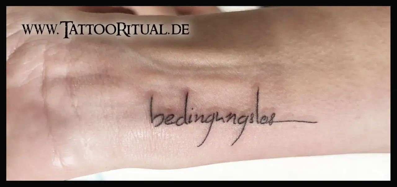 Feine Fineline Tattoo Schriftarten zieren die Haut mit dem Wort 