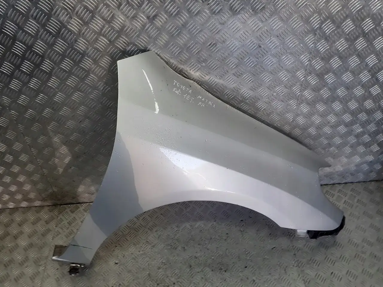 Srebrny błotnik do Toyota Matrix, z widocznymi śladami użytkowania.