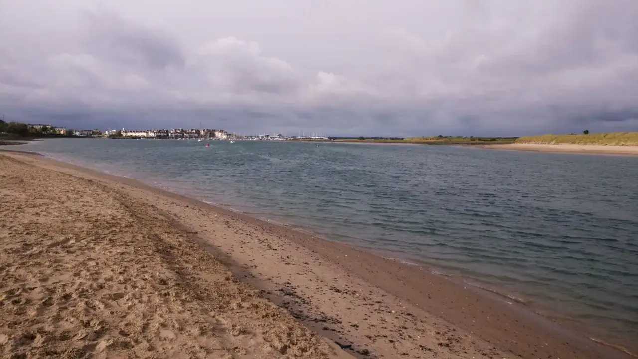 Sandiger Emden Strand mit Blick auf die Stadt und den Hafen. Grauer Himmel &uuml;ber dem Wasser.
