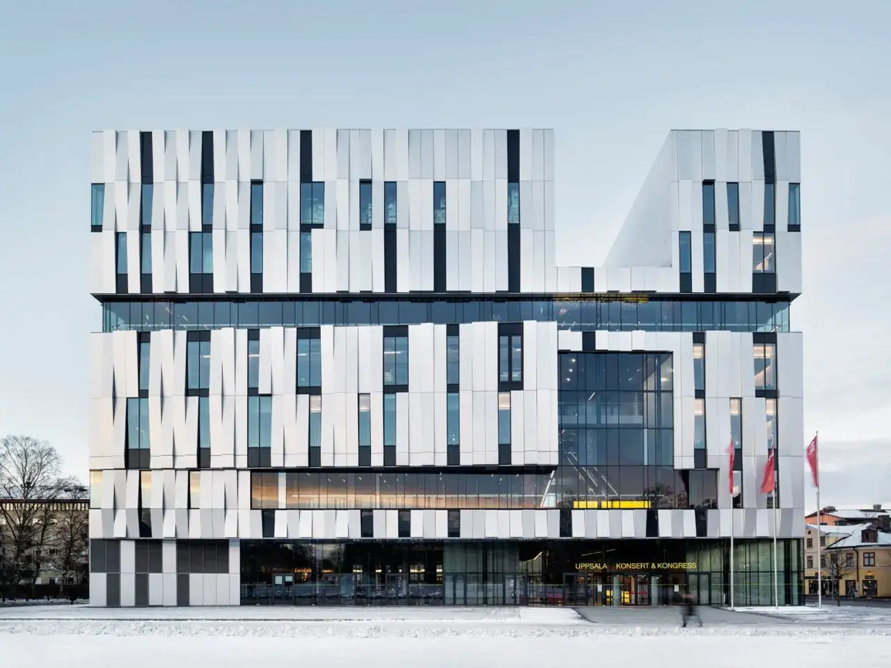 Uppsala Konsert & Kongress, en modern byggnad med en unik fasad av vita paneler och glas, står i snö.