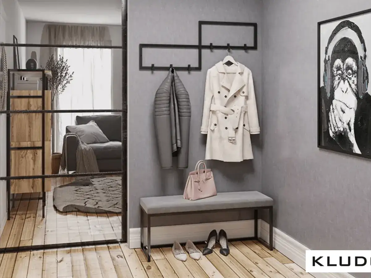 Przedpokój loft inspiracje: szary ławka, płaszcze na wieszaku, torebka, buty i obraz z małpą.