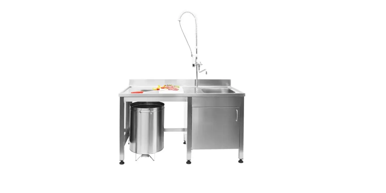 Banco da lavoro in acciaio inossidabile, con lavello, rubinetto a molla, tagliere con carne e verdure, cestino. L'acciaio inossidabile, significato di igiene e durabilità.