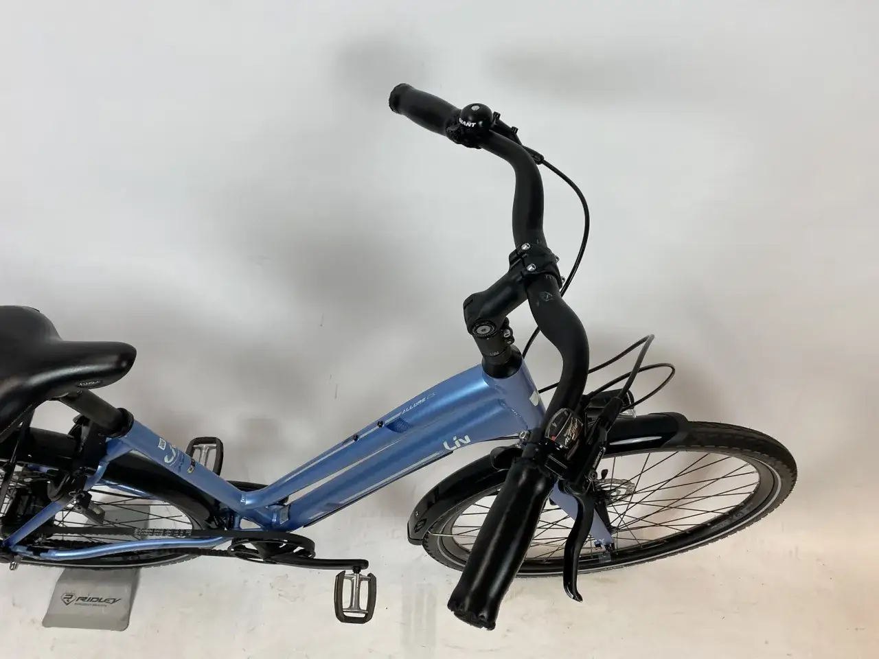 Blauwe simpele stadsfiets met een comfortabel zadel en een bel op het stuur, klaar voor een ritje door de stad.