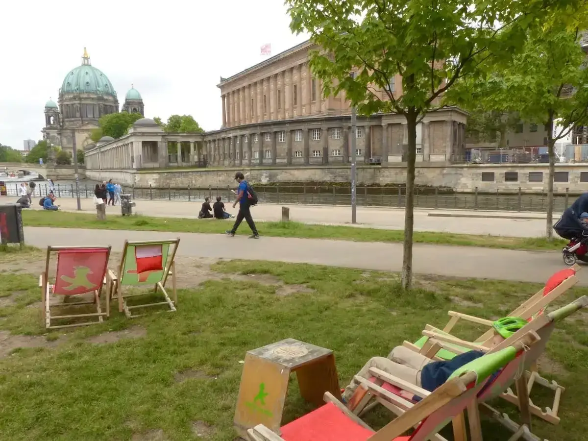 Entspannte Liegestühle am Spreeufer, mit Blick auf den Berliner Dom. Ein perfekter Ort für Berlin Geheimtipps abseits des Trubels.