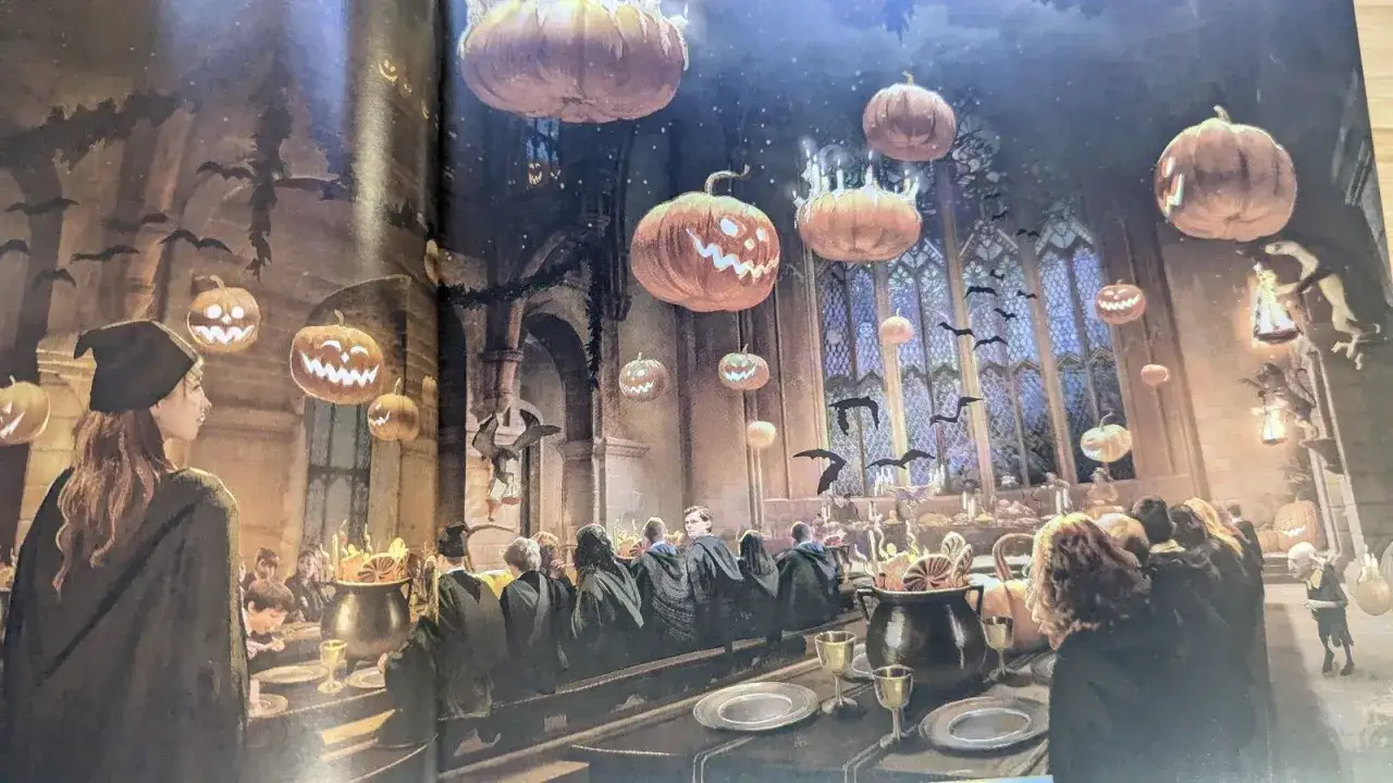 Uczta w Hogwarcie z dyniami i nietoperzami, jak w Hogwart Legacy 2. Studenci siedzą przy stołach, a nad nimi unoszą się latające dynie.