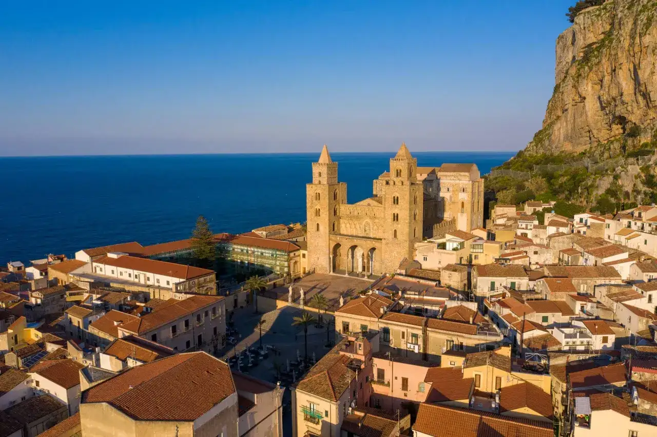 Cefal&ugrave; cosa vedere: la maestosa Cattedrale Normanna domina il borgo con il mare sullo sfondo, un'immagine iconica della Sicilia.