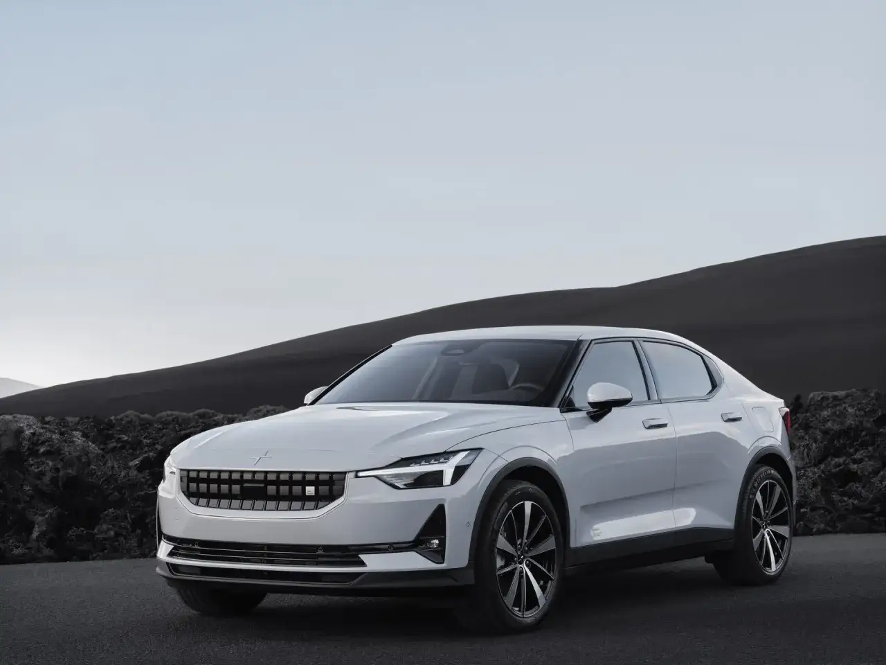 Biały Polestar 2 na tle surowego krajobrazu. Czy optymalizacja Polestar jest warta swojej ceny?