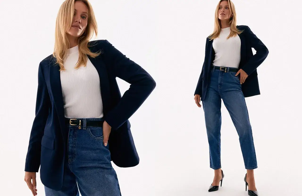 Kobieta w granatowej marynarce, białym golfie i jeansach prezentuje styl basic damski. Elegancki, ale swobodny zestaw.