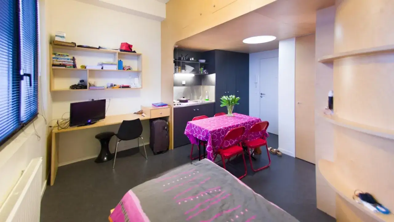 Chambre d'&eacute;tudiant am&eacute;nag&eacute;e pour une ann&eacute;e sabbatique apr&egrave;s le bac : coin bureau, kitchenette, table et lit.