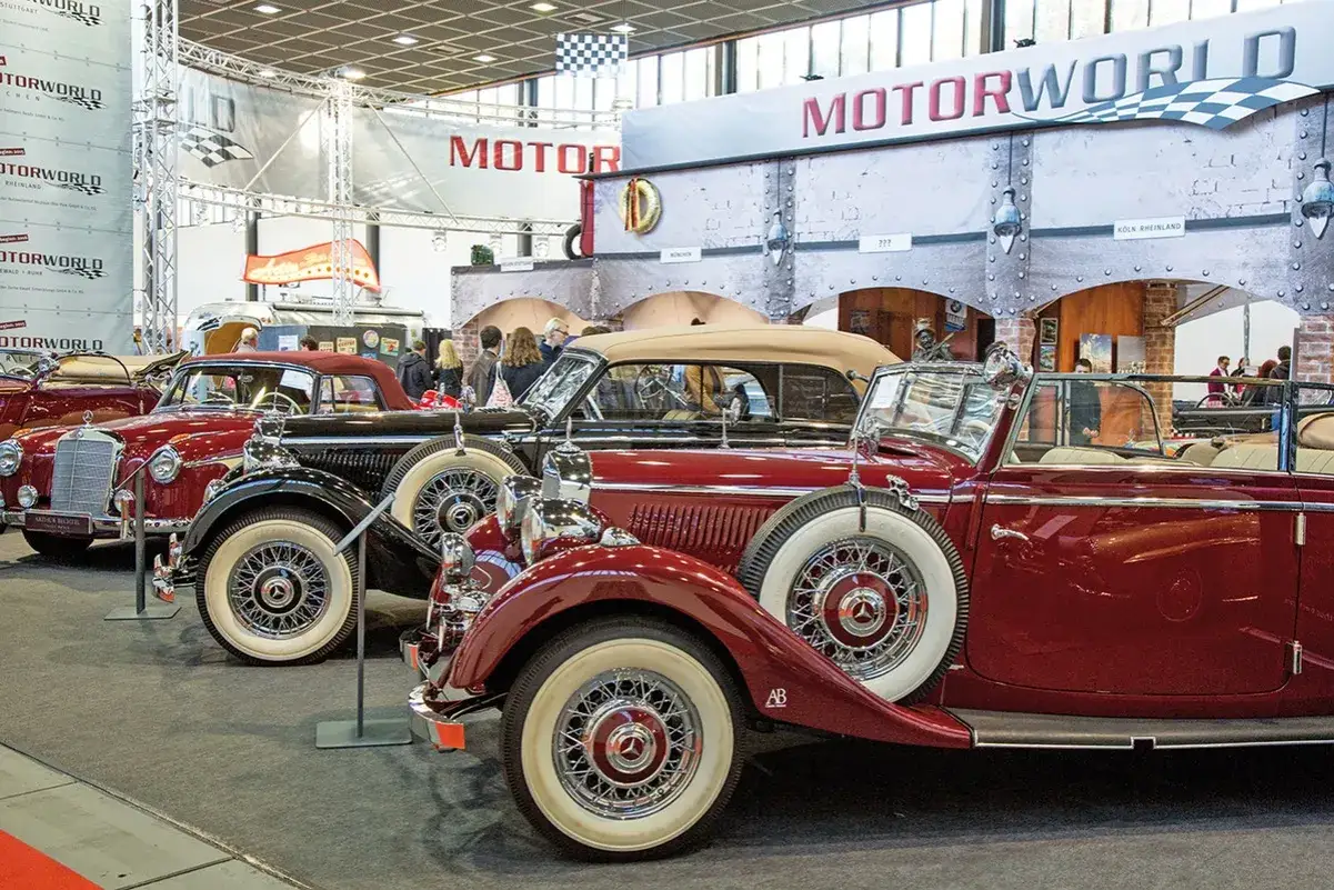 Gl&auml;nzende Oldtimer bei einem Oldtimertreffen Berlin. Mehrere rote und schwarze Cabrios mit Ersatzr&auml;dern stehen ausgestellt.