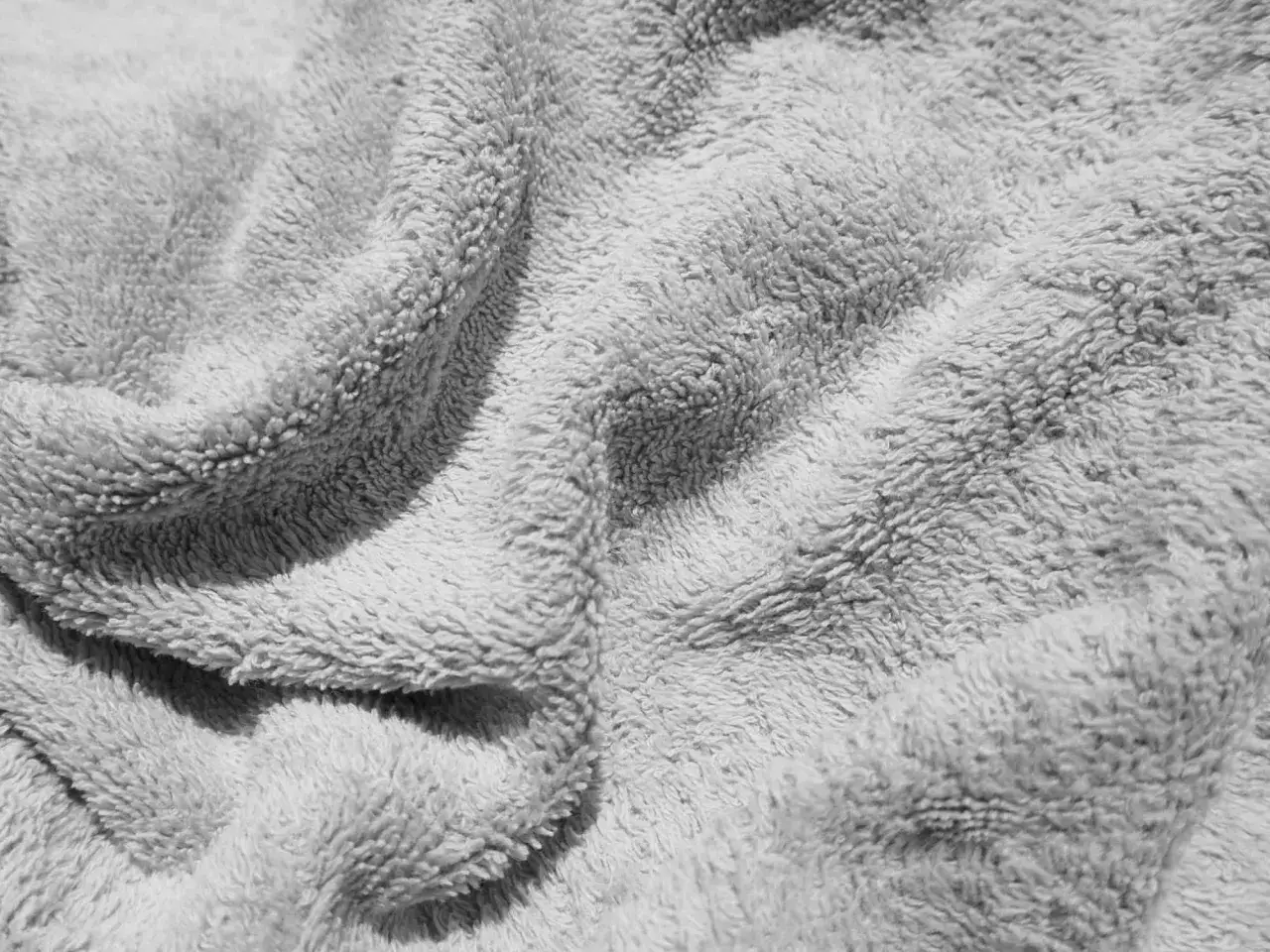 Close-up of a soft, grey terry cloth towel, its plush loops creating a textured, inviting surface.
