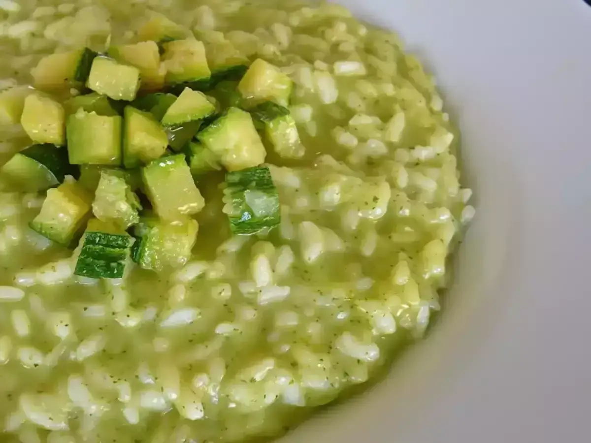 Un cremoso risotto con zucchine, guarnito con cubetti di zucchine fresche. Un piatto leggero e gustoso.