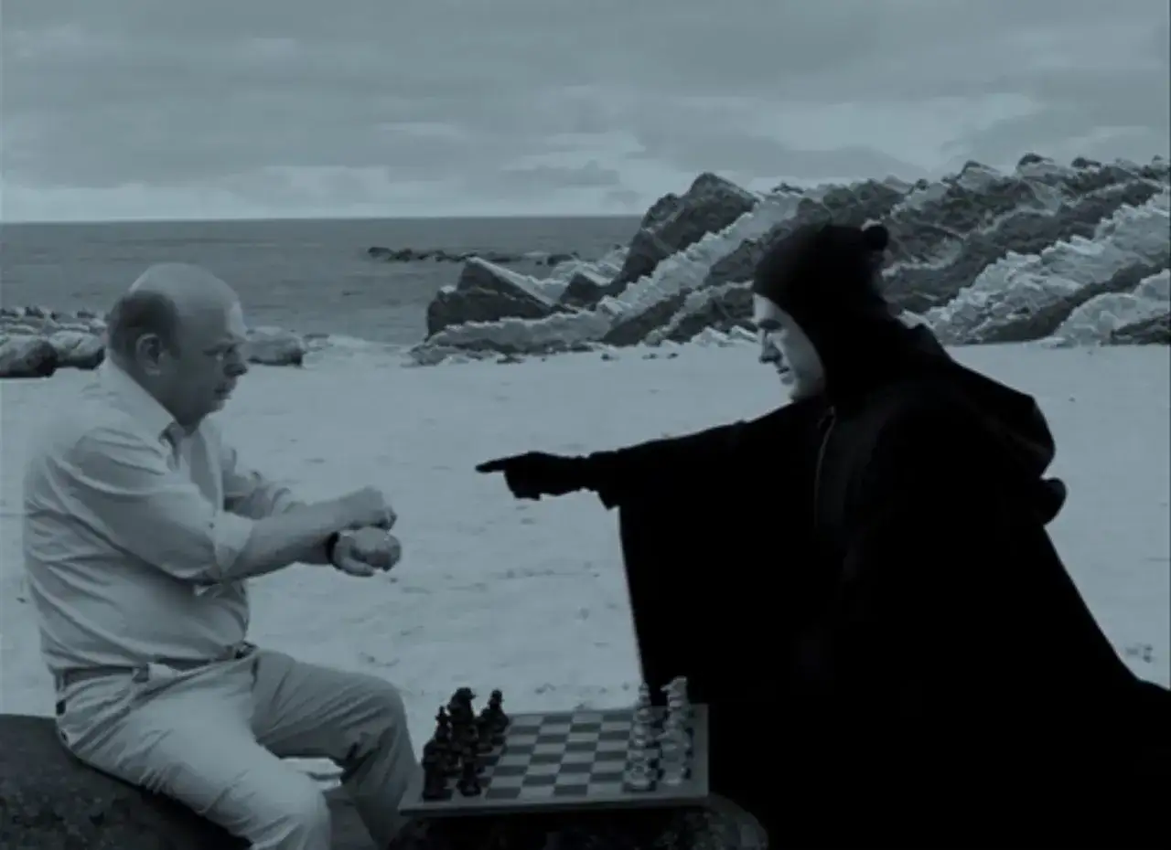 Szene aus Filme von Christoph Waltz: Ein Mann spielt Schach gegen den Tod am Strand.