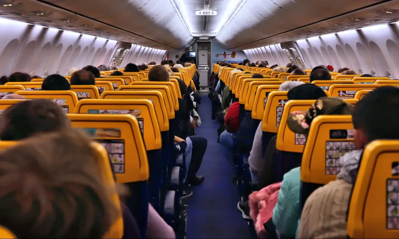 Wnętrze samolotu Ryanair z pasażerami. Czy opłata transakcyjna Ryanair jest ukryta w cenie biletu?