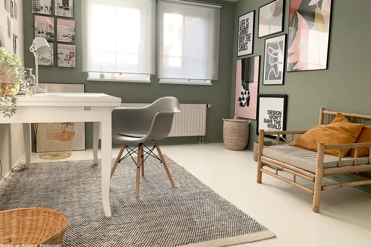 Grüne wandfarbe im Arbeitszimmer, mit Schreibtisch, Stuhl, Sofa und Bildern.