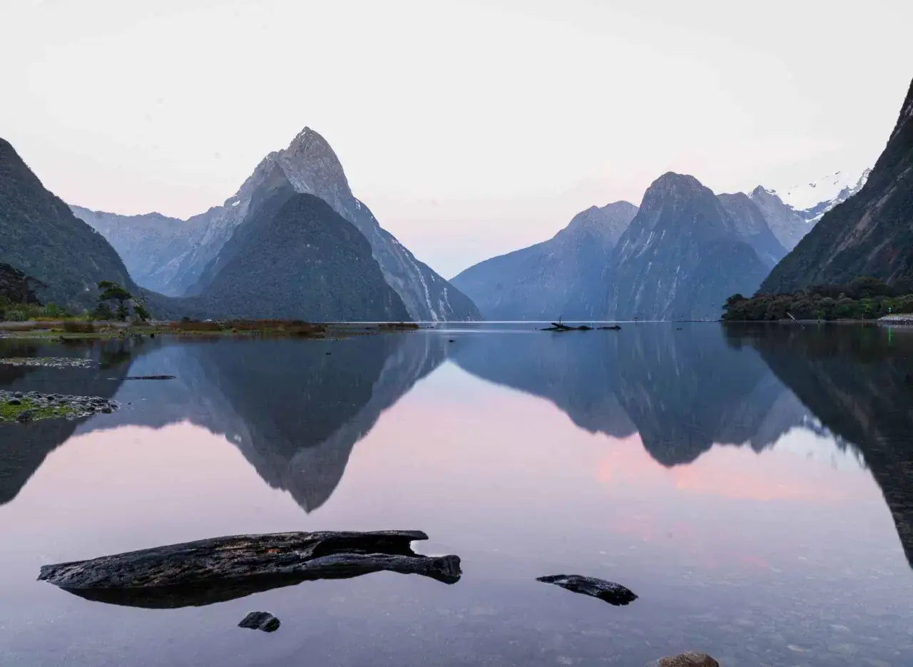 Impresionante reflejo de monta&ntilde;as en un lago sereno, un paisaje imperdible de Nueva Zelanda que ver.