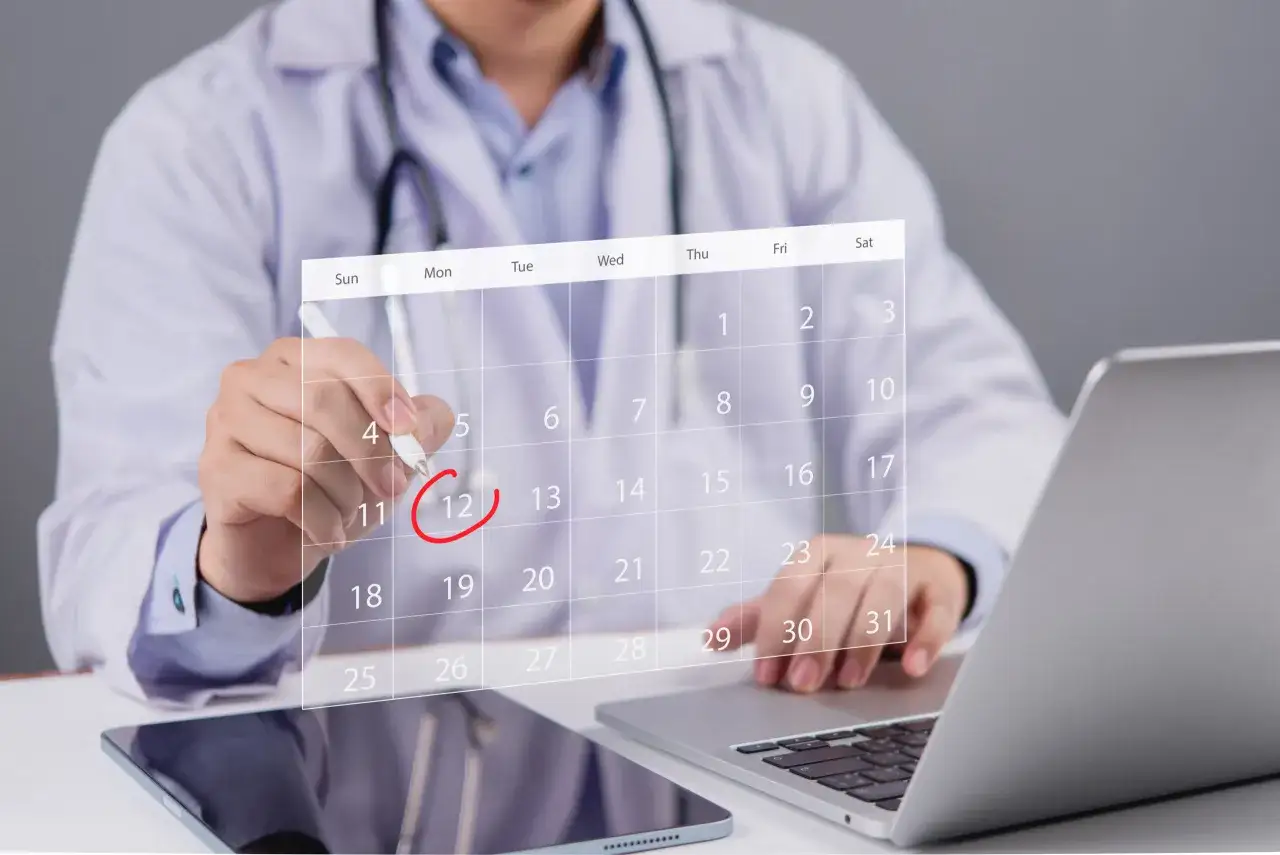 Medico con stetoscopio che segna il 12 su un calendario digitale, simbolo di gestione appuntamenti con Doctolib Pro.