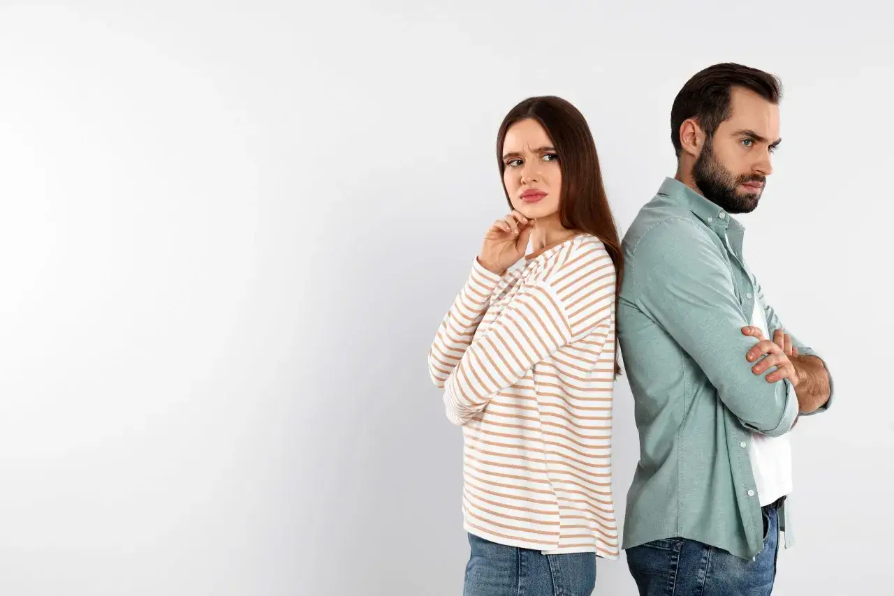 Un couple se tourne le dos, l'air contrarié. Elle semble déçue, lui distant. Une scène qui évoque le sentiment de ghoster quelqu'un qu'on aime.