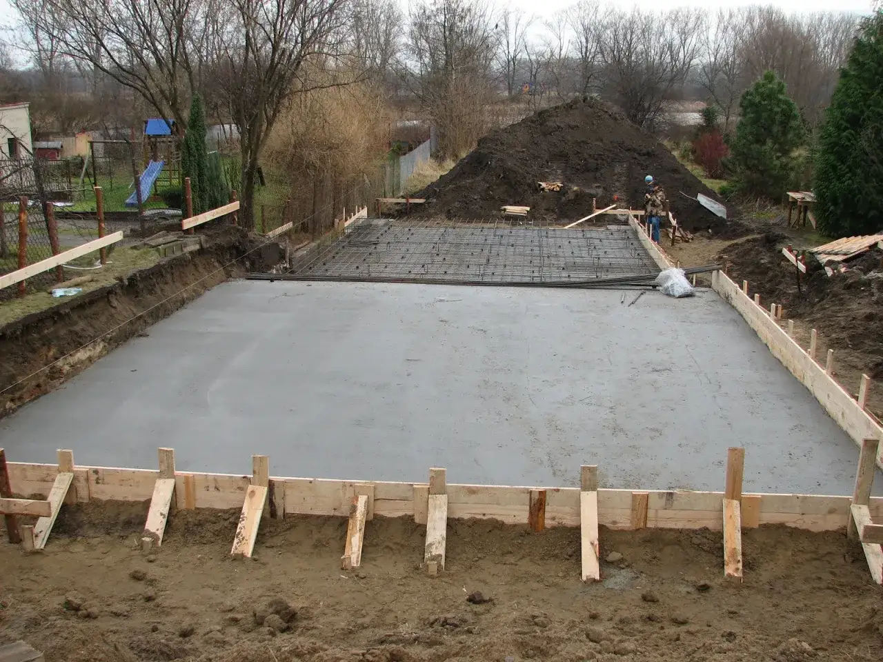 Świeżo wylany beton na fundamencie domu, gotowy do schnięcia. Czas schnięcia fundamentu pod dom zależy od wielu czynników.