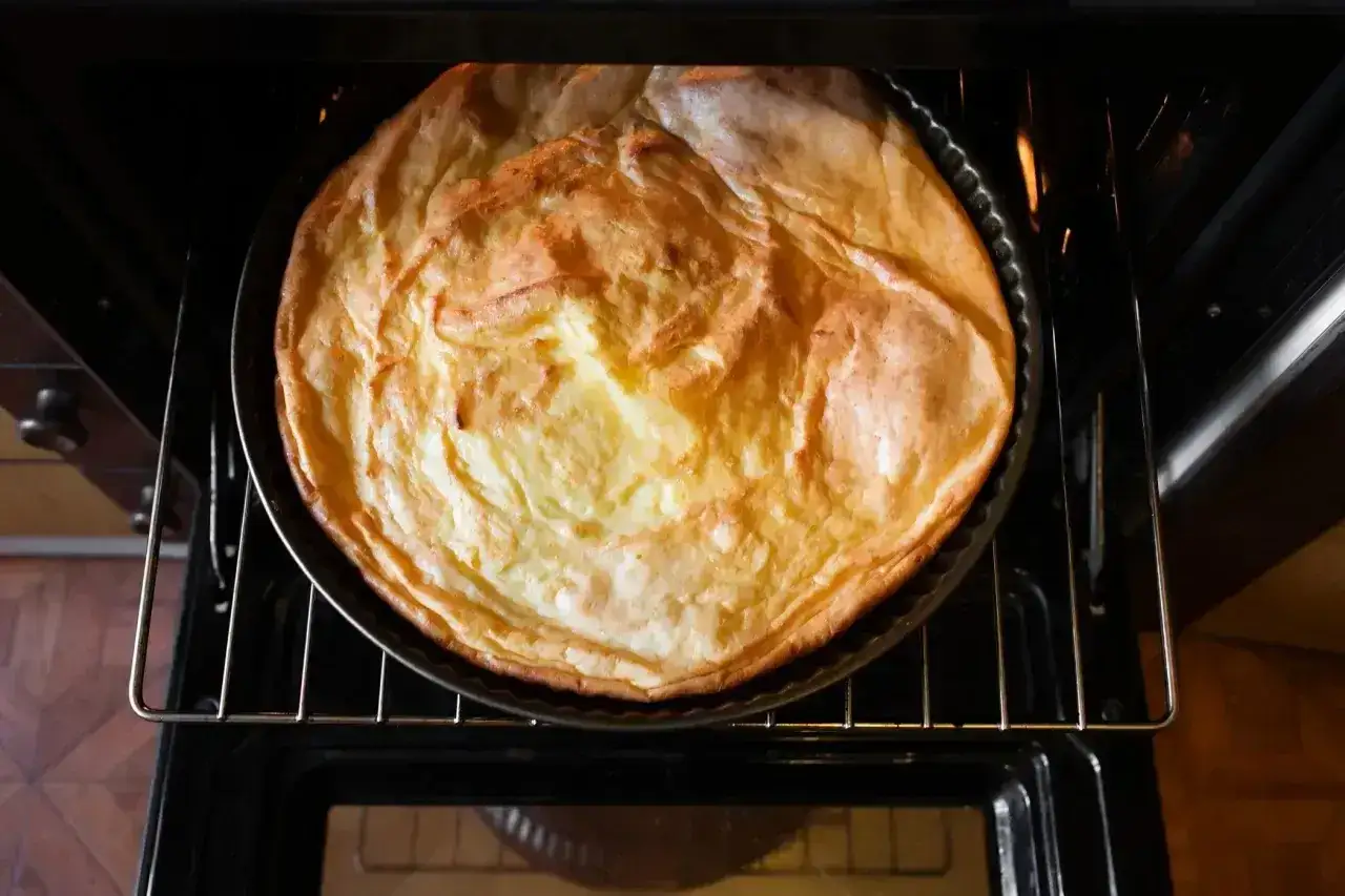 Puszysty sernik piecze się w piekarniku. Idealna temperatura, by uzyskać złocisty kolor i delikatną konsystencję.