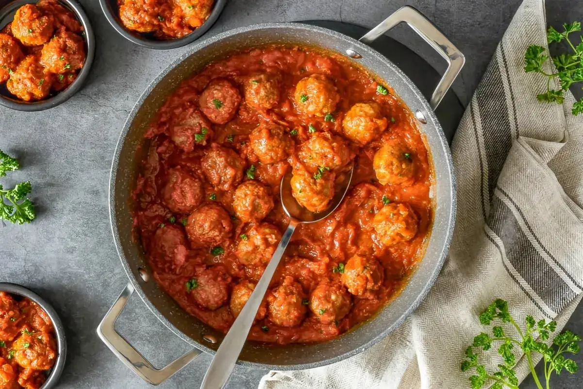 Sabrosas alb&oacute;ndigas con tomate, reci&eacute;n salidas de la sart&eacute;n, listas para servir. Un cl&aacute;sico reconfortante.