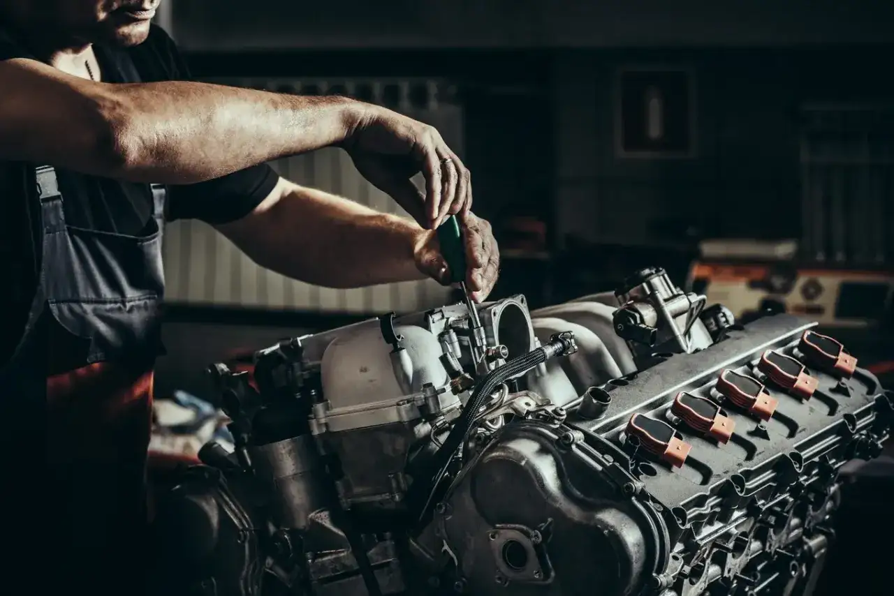 Mechanik naprawia silnik, kt&oacute;ry sprawia problemy z odpalaniem i gaśnięciem. To może być przyczyną problem&oacute;w z dieslem.