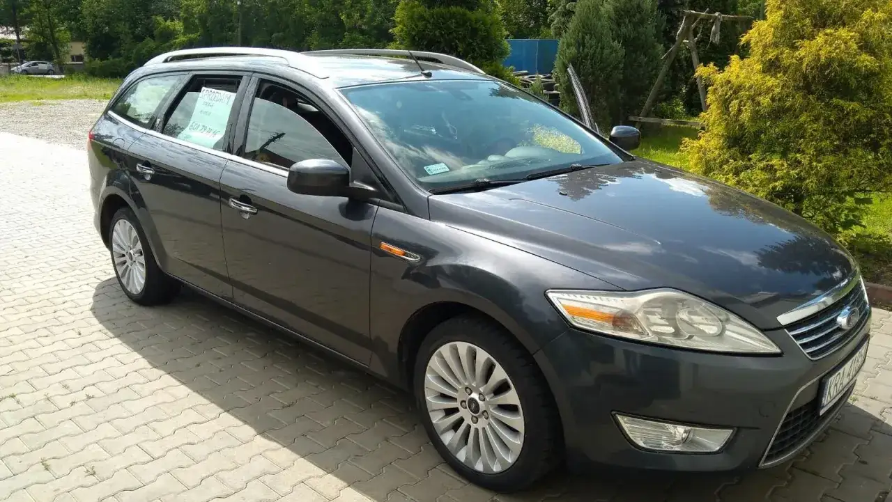 Ciemnoszary Ford Mondeo MK4 kombi stoi na podjeździe z kostki brukowej. Na szybie widoczny kartka 