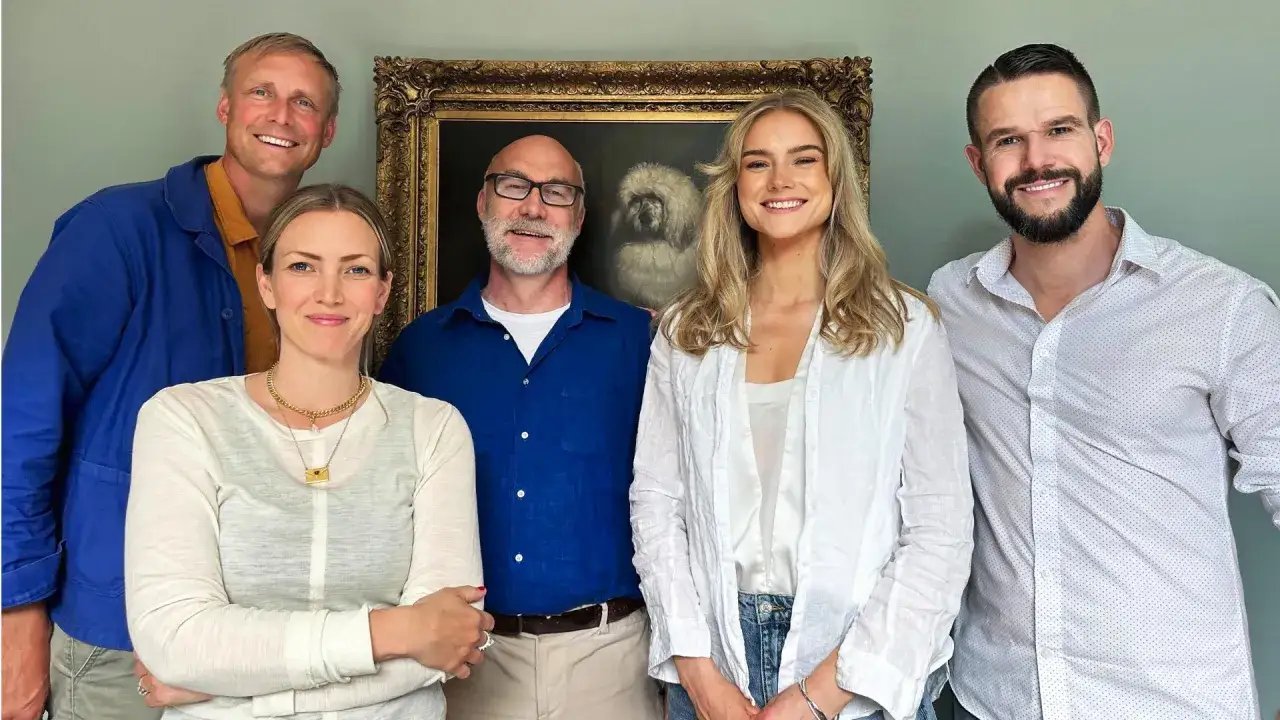 Johnny Kroneld och hans familj poserar glatt framf&ouml;r en hundportr&auml;tt.