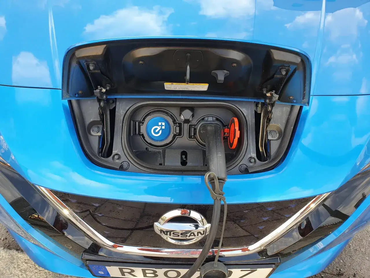 Bl&aring; Nissan Leaf med laddkabeln ansluten. Ett problem med laddningen kan uppst&aring; om kontakten inte sitter ordentligt.