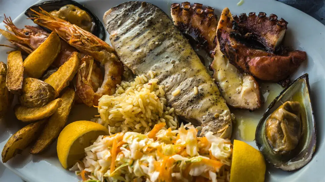 Talerz pełen owoców morza: grillowana ryba, ośmiornica, krewetki, mule, frytki i sałatka. Idealny posiłek, gdy zastanawiasz się, dlaczego nie je się mięsa w piątek.