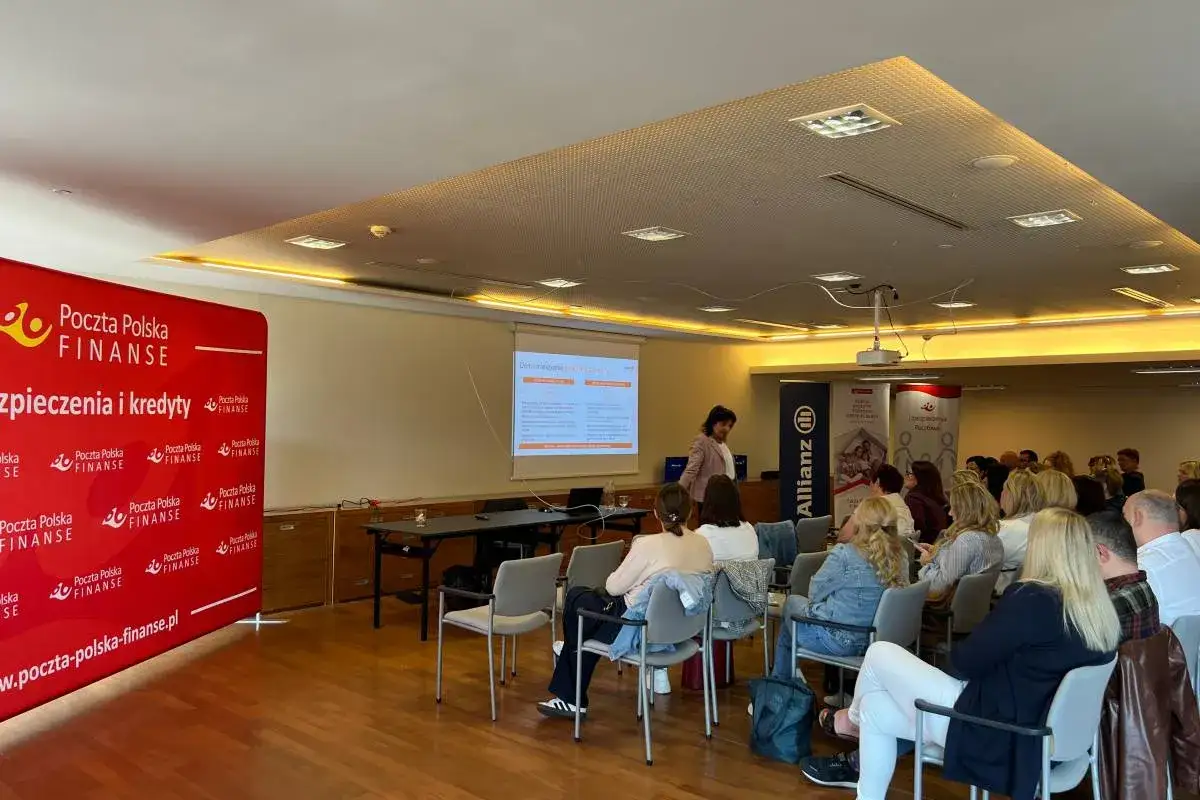Prezentacja finansowa z udziałem ekspertów i publiczności w sali konferencyjnej.