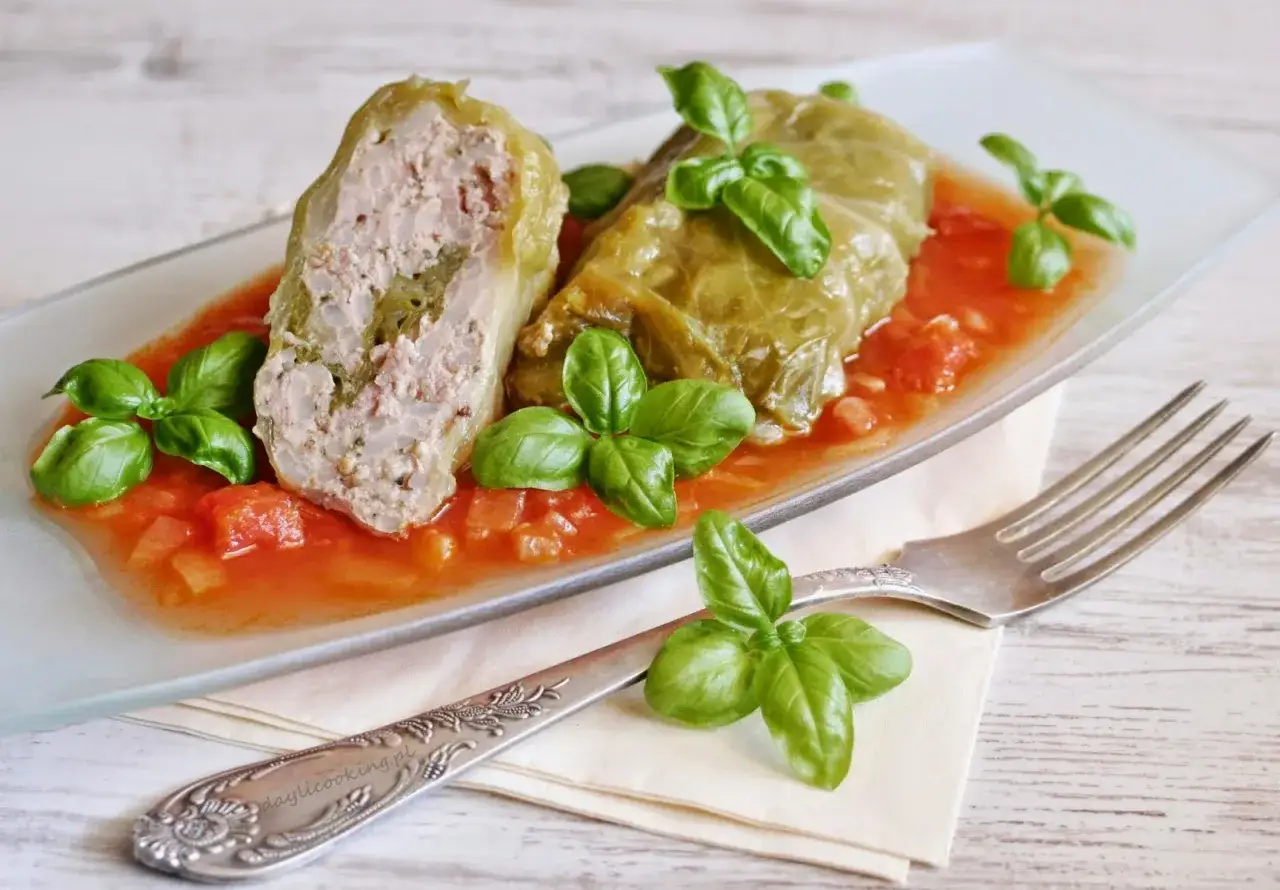 Gołąbki z farszem mięsnym w sosie pomidorowym, ozdobione bazylią. Idealny przepis na gołąbki na 1kg mięsa.