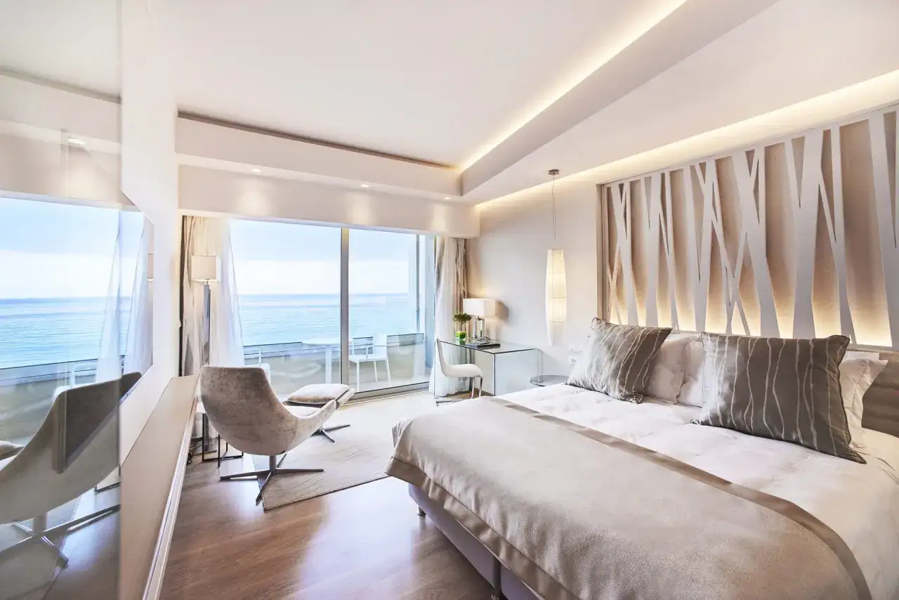 Luksusowy pokój z widokiem na morze, idealny na pobyt w Rodos Palace. Wygodne łóżko, fotel i balkon zapraszają do relaksu.