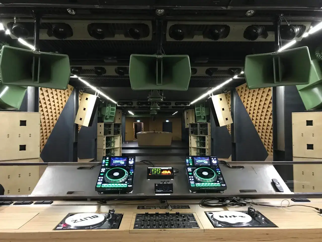 DJ-Pult mit zwei Denon-Decks, Turntables und vielen gr&uuml;nen Lautsprechern. Bereit f&uuml;r fette DJ-Musik.