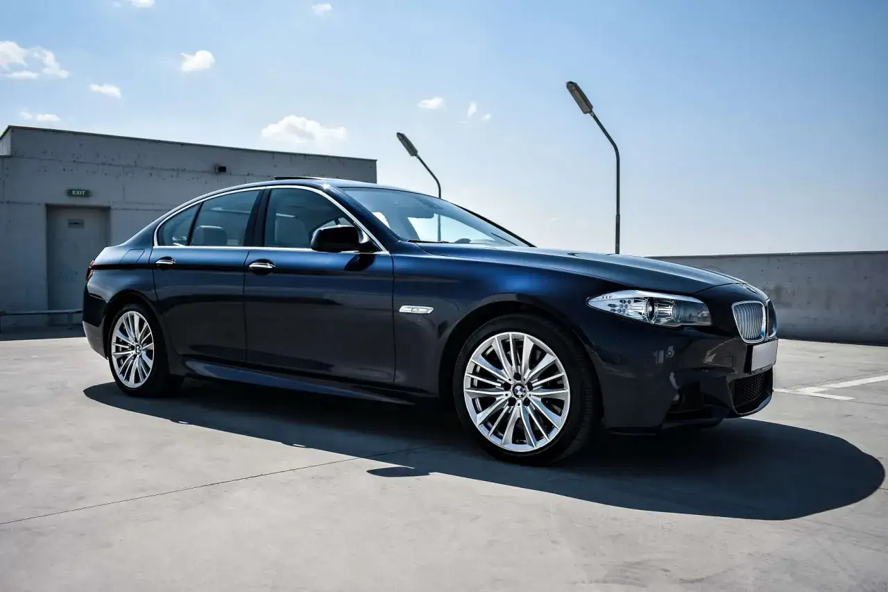 Ciemnoniebieskie BMW na parkingu. Idealny wybór dla osób szukających elastycznego rozwiązania, jakim jest leasing zwrotny.