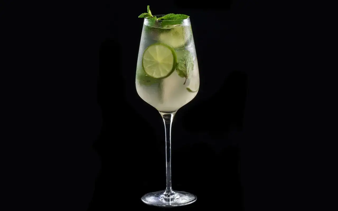 Ett svalkande southside drink med lime och mynta i ett elegant glas, perfekt f&ouml;r en varm sommardag.